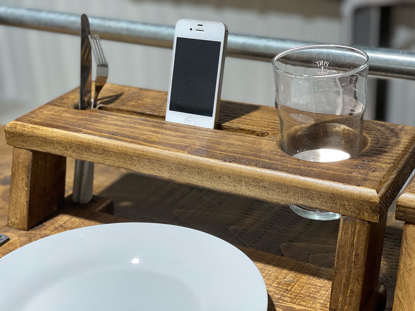 Handmade rustic wooden multi-function tray with plate, wine glass, cutlery, and phone holders by Spire Carpentry.