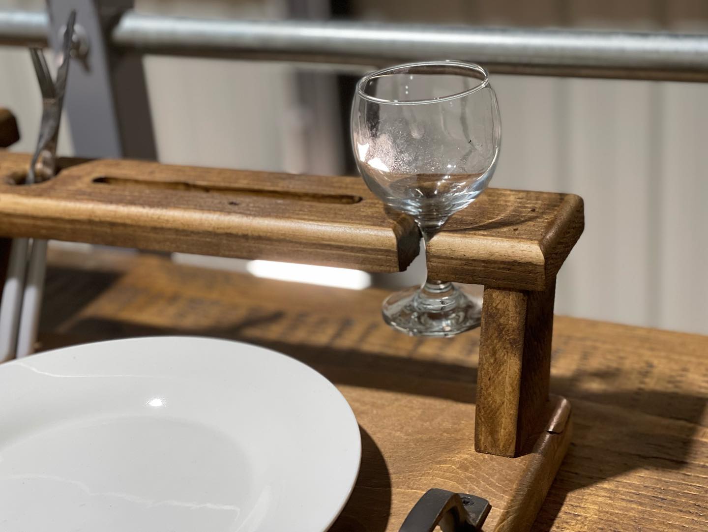 Handmade rustic wooden multi-function tray with plate, wine glass, cutlery, and phone holders by Spire Carpentry.