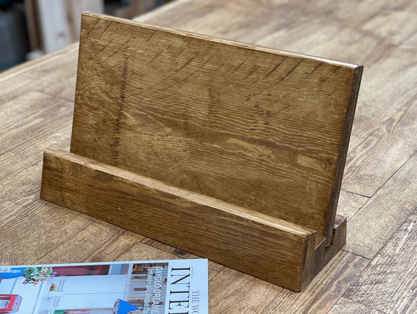 Handmade rustic wooden cookbook stand holding Jamie Oliver’s 5 Ingredients recipe book, crafted by Spire Carpentry UK.